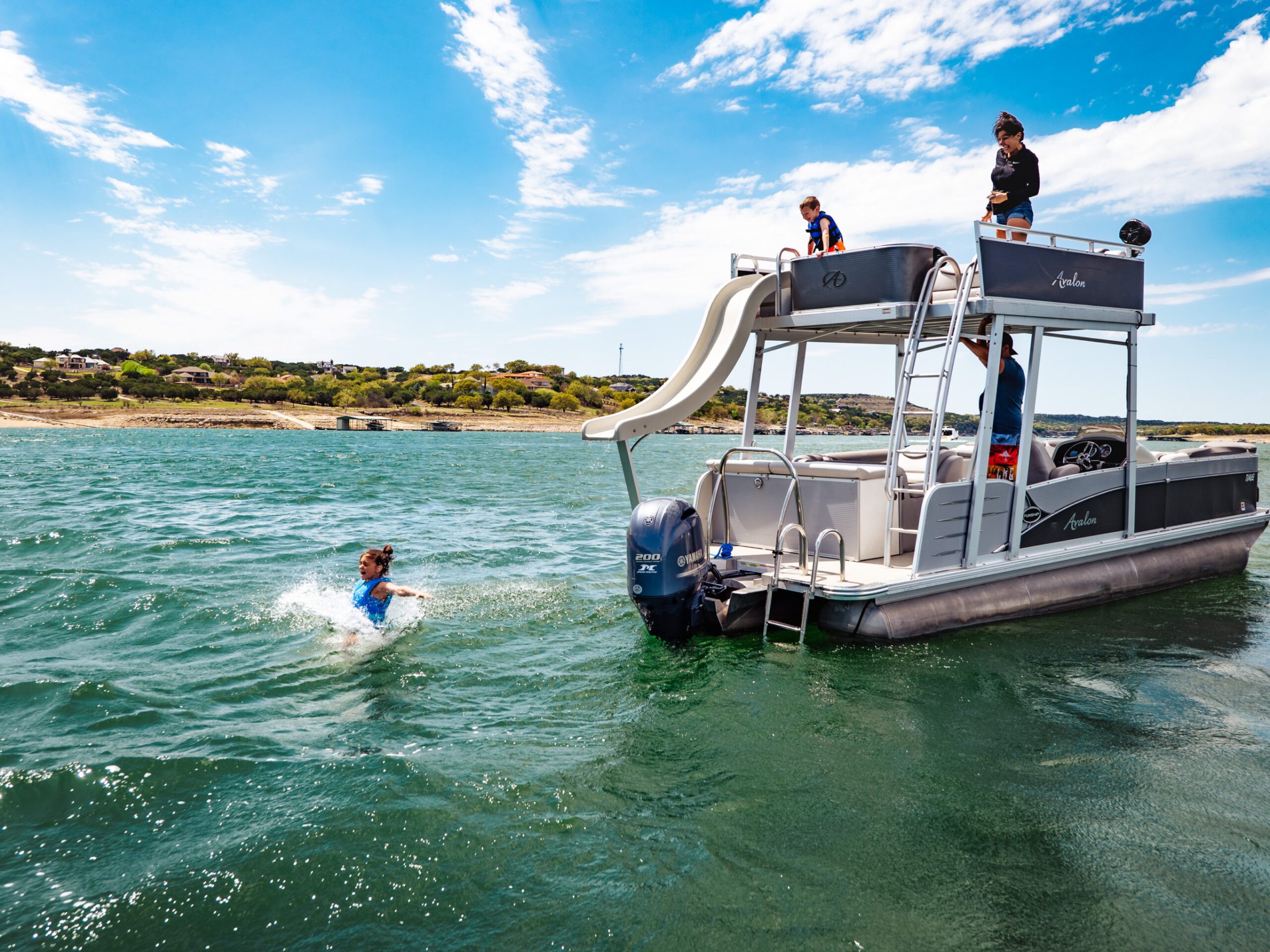 a group of people riding on the back of a boat in the water