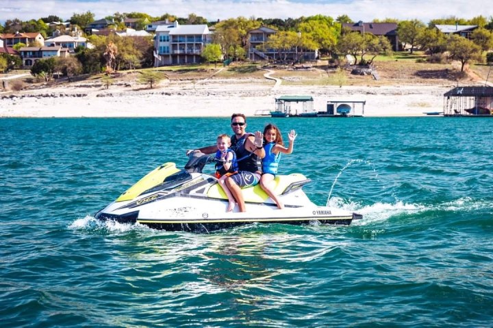 a man riding on the back of a boat in the water